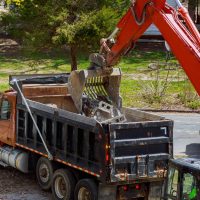 excavator-picks-up-construction-waste-for-loading-CVPJ63X.jpg